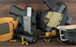 two pistol holsters with handguns, bullets and leather belts