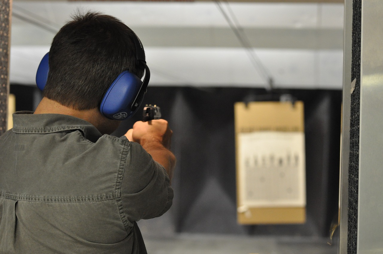 a man aiming the pistol to the target